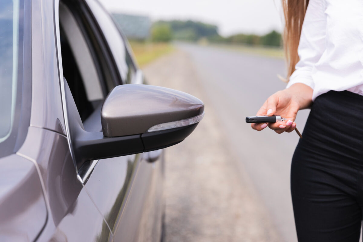 une femme est en train d'ouvrir la voiture avec ses clés